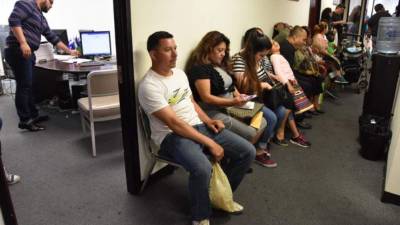 Varias personas esperan su turno para renovar su Estatus de Protección Temporal. Foto: EFE/Archivo.