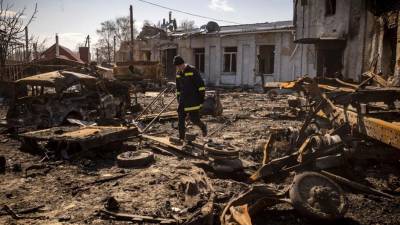 Un bombero ucraniano camina entre los escombros en la ciudad nororiental de Trostianets.