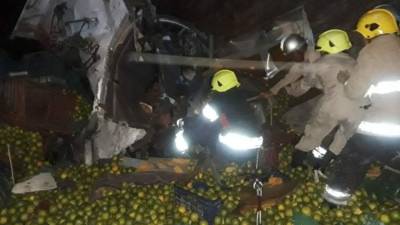 Bomberos trabajando para rescatar a los fallecidos y heridos producto del accidente de tránsito este lunes.