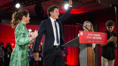 Justin Trudeau flanqueado por su esposa Sophie Gregoire y sus hijos Ella-Grace y Xavier, saluda con la mano cuando llega para pronunciar su discurso de victoria.