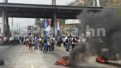 Los estudiantes queman llantas frente al peaje ubicado en la zona sur de San Pedro Sula, zona norte de Honduras.
