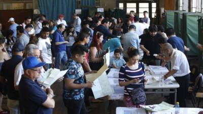 STG34. SANTIAGO DE CHILE (CHILE), 19/11/2017.- Un grupo de personas acuden a su puesto de votación hoy, domingo 19 de noviembre de 2017, durante la jornada de elecciones y parlamentarias en Santiago (Chile). Además de elegir al presidente de la República, tras la votación de este domingo se renovarán 23 escaños del Senado, toda la Cámara de Diputados, de 155 miembros, y 278 consejeros regionales. EFE/Esteban Garay