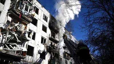 Los bomberos trabajando en un incendio en un edificio después de los bombardeos en la ciudad de Chuguiv, en el este de Ucrania.