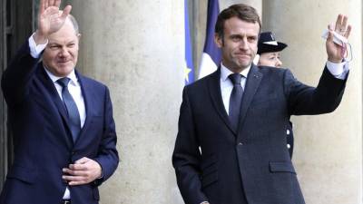El presidente francés Emmanuel Macron (derecha) saluda al canciller alemán Olaf Scholz en el Palacio del Elíseo, en París.