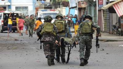 Soldados llevan en camilla a un compañero después de que una bomba improvisada explotara junto a un vehículo militar en la ciudad de Jolo. Foto AFP