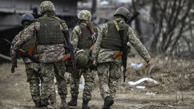 Militares ucranianos llevan el cuerpo de un camarada en una camilla en la ciudad de Irpin, al noroeste de Kiev.