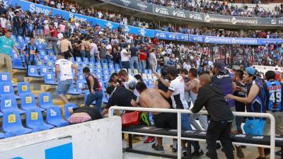 Los seguidores de Atlas pelean contra los seguidores de Querétaro durante el partido de fútbol del torneo clausura mexicano entre Querétaro y Atlas en el estadio Corregidora.