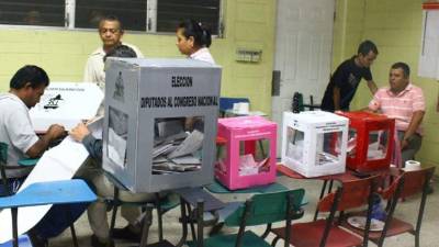 En imagen se observa cómo están distribuidos los integrantes de una mesa electoral en San Pedro Sula. Foto de archivo.