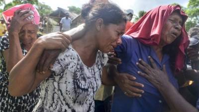 Familiares de una de las víctimas de un accidente de bote el pasado miércoles, lloran su muerte durante su funeral en Prumitara Village, cerca de Puerto Lempira, Honduras. Foto: AFP