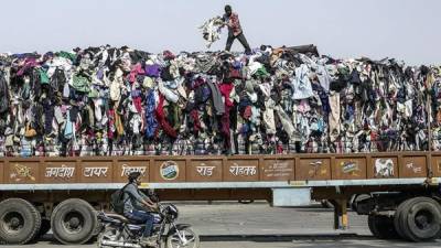 Camiones que transportan fardos de ropa en su camino hacia Kandla, India. El país permite el procesamiento y la reexportación de la ropa usada, pero no su venta.