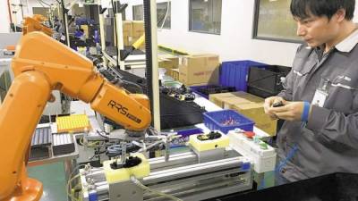 Un brazo robótico instala partes en un ratón de computadora fabricado por Rapoo Technology en la ciudad de Shenzen.