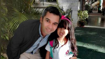 El doctor Josué Molina se preparó como científico de particulas en Brasil. Aparece en la foto junto a su pequeña hija.