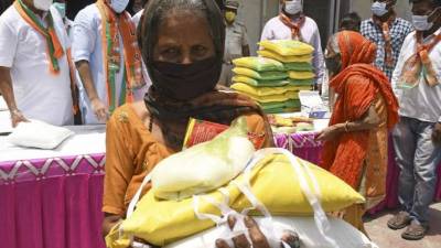 Personas necesitadas recolectan artículos comestibles distribuidos por líderes del Partido Bharatiya Janata durante un cierre de fin de semana impuesto para frenar la propagación del coronavirus. Foto AFP