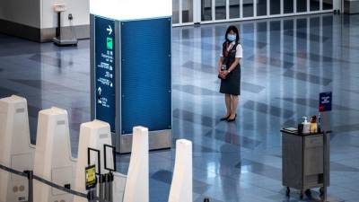 Un miembro del personal espera en una sala de salidas vacía en el aeropuerto internacional Haneda de Tokio.