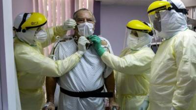 Herman Bern de Panamá, un caso confirmado de COVID-19, es asistido por médicos en la unidad de cuidados intensivos del Hospital de Paitilla. Foto AFP