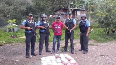 Elementos de la DPI custodian al detenido después de un allanamiento.