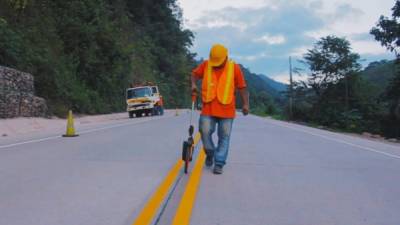 Obreros trabajan en la señalización de la carretera.