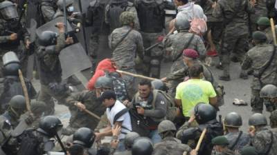 Migrantes hondureños, parte de una caravana que se dirige a los Estados Unidos, chocan con las fuerzas de seguridad guatemaltecas en Vado Hondo. Foto AFP