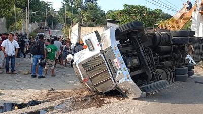 El camión tráiler que transportaba a migrantes por el sur de México yace de costado después del accidente.