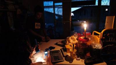 Ciudadanos y empresarios expresaron su malestar por las pérdidas que les generan los apagones. En la foto, en una pulpería se alumbran con velas tras un corte de energía. Foto: Yoseph Amaya