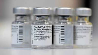 (FILES) In this file photograph taken on January 22, 2021, empty vials of the Pfizer-BioNTech Covid-19 disease vaccine are displayed at the regional corona vaccination centre in Ludwigsburg, southern Germany. - Pfizer sharply increased its projections for 2021 revenues and profits on May 4, 2021, citing much higher sales from its Covid-19 vaccine sales. The drugmaker now estimates 2021 revenues of $26 billion from the vaccine, up from $15 billion previously. Pfizer sees profits of between $3.55 and $3.65 per share, up 45 cents from the previous range. (Photo by THOMAS KIENZLE / AFP)