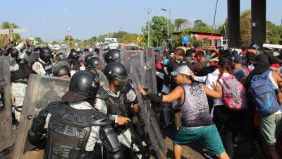Miembros de la Guardia Nacional chocan hoy con migrantes en la ciudad de Tapachula, estado de Chiapas (México).