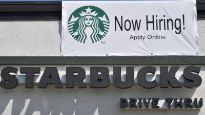 Un café Starbucks con un rótulo anunciando que ofrecen empleo.
