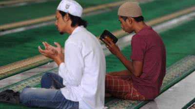 Dos jóvenes musulmanes oran y leen en una mezquita de Banda Aceh, Indonesia, el país con la mayor población islámica del mundo.