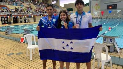 Michell Ramírez, Omar Oyuela y Jaime Uribe posando con la bandera de Honduras.