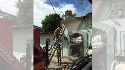 Los bomberos brindando la atención respectiva en el negocio donde colapsó el techo.