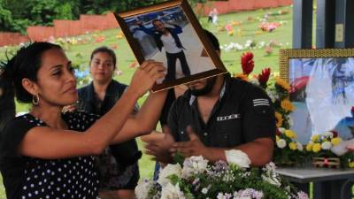 La madre del pequeño levanta una fotografía mientras los presentes en el sepelio dedicaron un minuto de aplausos a Cristopher Mejía Reconco.