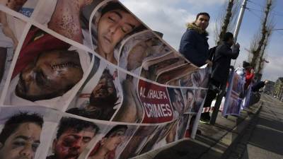 Un pequeño grupo colocó pancartas con las fotos de los deportistas torturados por manifestarse en contra del régimen durante la 'revolución de la perla'. Foto AFP/Olivier Morin.
