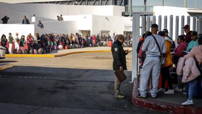 Migrantes hacen fila para solicitar un proceso de asilo en Estados Unidos, el 25 de enero de 2024 en el paso fronterizo del Chaparral en Baja California (México).