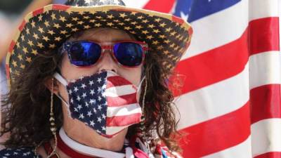 Foto referencial una mujer usando una máscara de la bandera estadounidense. AFP