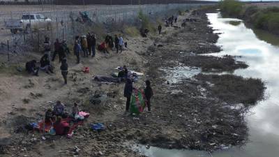 Migrantes permanecen en las inmediaciones del Río Bravo, junto al alambrado que divide a México con Estados Unidos, este miércoles, en Ciudad Juárez.