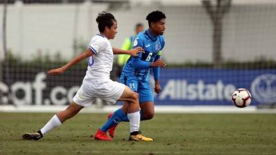 El jugador hondureño Elix Gómez lucha por el balón con un salvadoreño.