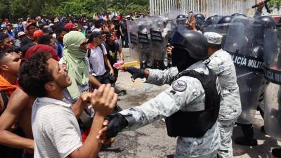 Personal de la Guardia Nacional (GN) impiden el paso este miércoles, a migrantes a las oficinas del Instituto Nacional de Migración (INM) en el municipio de Huixtla, en Chiapas (México). EFE