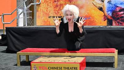 La cantautora estadounidense Cyndi Lauper sostiene sus manos manchadas de cemento durante la ceremonia de Mano y Huella frente al Teatro Chino TCL en Hollywood el 4 de junio de 2024.