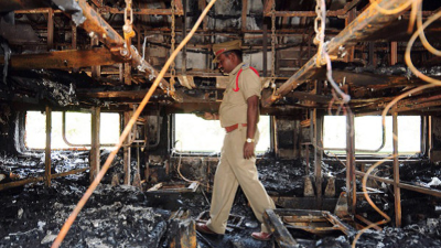 Un policía revisa los escombros para verificar si hay cuerpos calcinados en el vagón del tren de pasajeros.