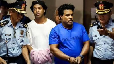 Ronaldinho y su hermano Roberto fueron esposados antes de rendir ante el juzgado de Asunción. Foto EFE