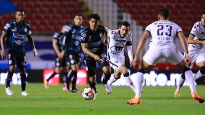 Joshua Canales conduce la pelota ante la marca de varios adversarios de los Pumas.