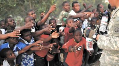 Survivors of Tuesday's earthquake extend their arms as U.S. troops with the 82nd Airborne Division distribute water in Port-au-Prince, Sunday, Jan. 17, 2010. The troops gave out over 9,000 bottles of water and 2,000 meals Sunday. (AP Photo/Jae C. Hong)
