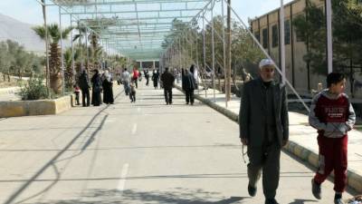 XYB01. Damascus (Syrian Arab Republic), 17/03/2018.- Civilians, who were evacuated from the Eastern Ghouta, walk in the garden of a makeshift center at al-Dweir area in the countryside of Damascus, Syria, 17 March 2018. According to media reports, the Syrian army and the Syrian Arab Red Crescent (SARC) evacuated 1500 civilians, mostly ill people and injured that need urgent medical attention, from rebels-held areas in Eastern Ghouta to Damascus. (Damasco, Siria) EFE/EPA/YOUSSEF BADAWI