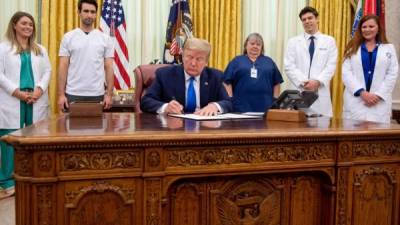 US President Donald Trump signs a Proclamation in honor of National Nurses Day in the Oval Office of the White House in Washington, DC, May 6, 2020. (Photo by SAUL LOEB / AFP)
