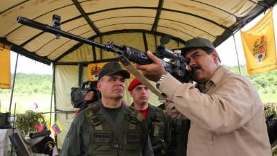 El Ministro de Defensa, Vladimir Padrino, observa al presidente Nicolás Maduro durante un entrenamiento militar cerca de Caracas.