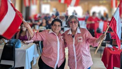 Suyapa Figueroa y Maribel Espinoza ondean la bandera del Partido Liberal durante una reunión política del movimiento “Todos Por Honduras”.
