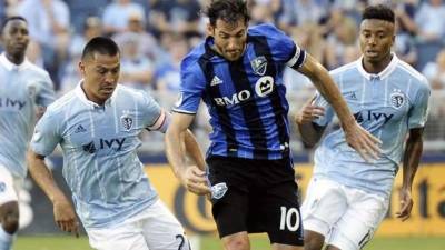 Roger Espinoza y su compañero Saad Abdul-Salaam persiguen a Ignacio Piatti del Impact Montreal.