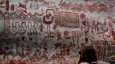 Fotografía de 2 de julio de 2018, de un hombre tomando fotografías de las pinturas rupestres encontradas en Cerro Azul, en el departamento de Guaviare (Colombia). EFE