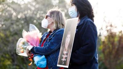 La enfermera Lorraine Gibson (R) sostiene una fotografía de Mari Donahue, una enfermera jubilada que murió de COVID-19 a principios de este mes, durante un evento organizado por la Asociación de Enfermeras del Estado de Nueva York para marcar el final de la Semana de la Enfermera y recordar a las víctimas.