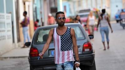 Un hombre transita por una calle de La Habana vestido con una camiseta con la bandera de Estados Unidos.